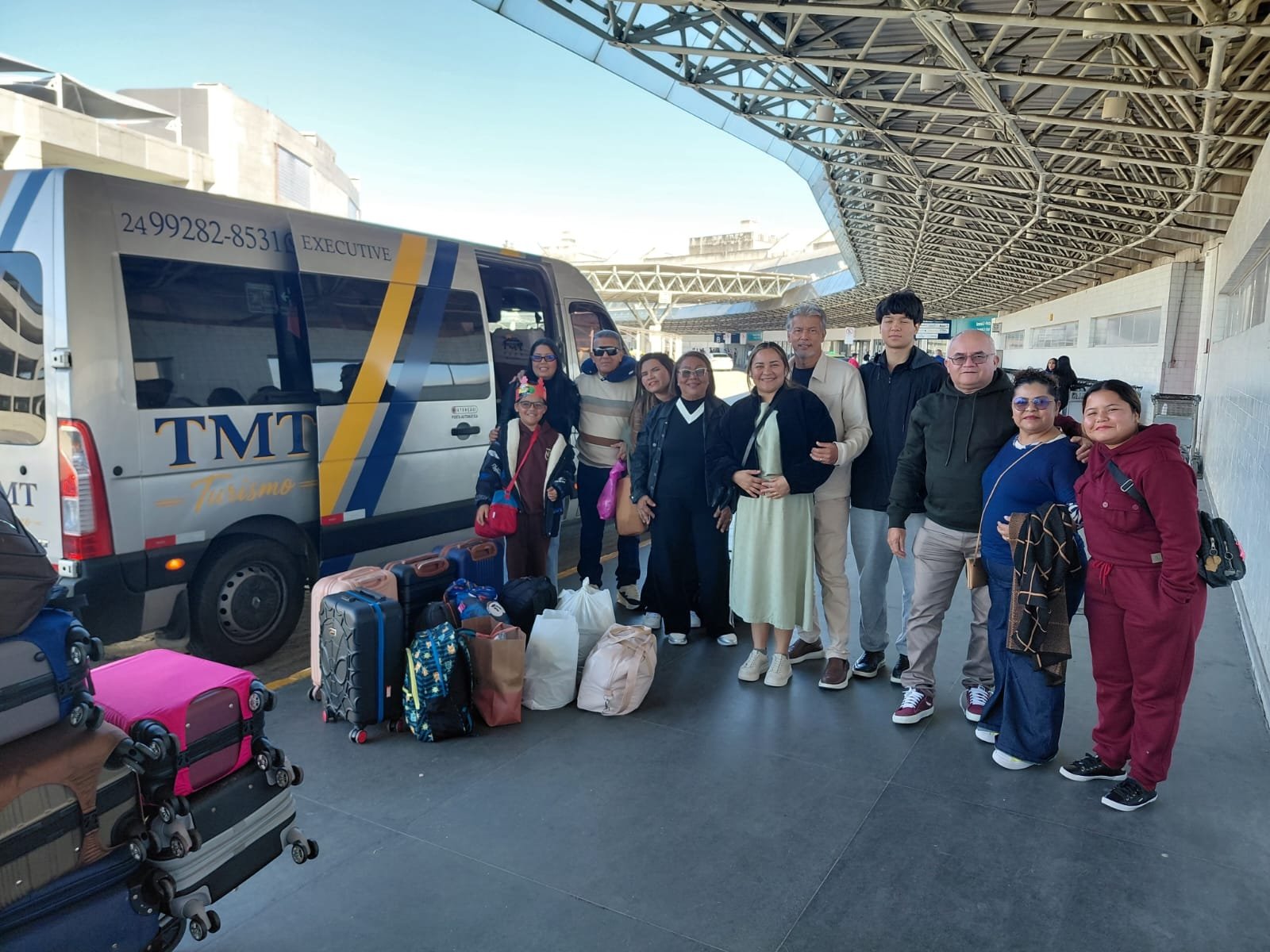 Família embarcando com malas na van da TMT Turismo