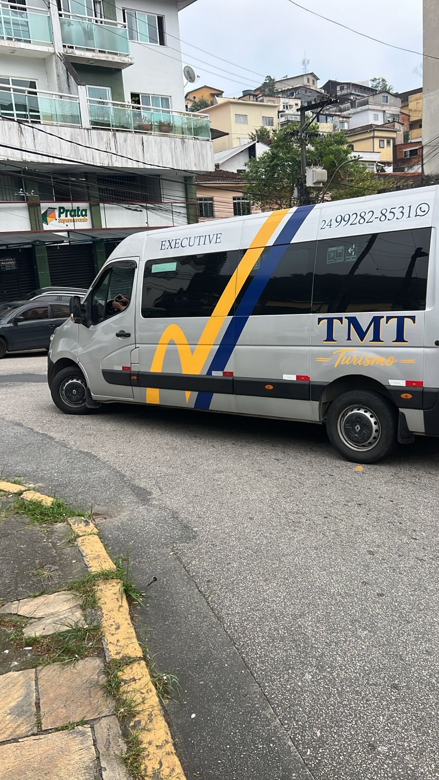Van executiva da TMT Turismo com a identidade visual da empresa